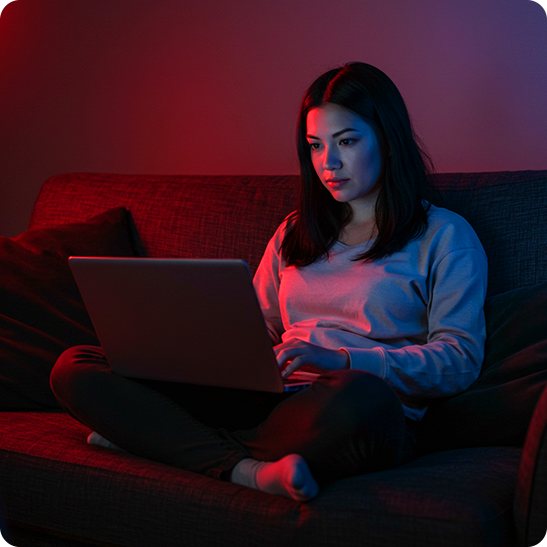 Woman working on a laptop while sitting on a couch